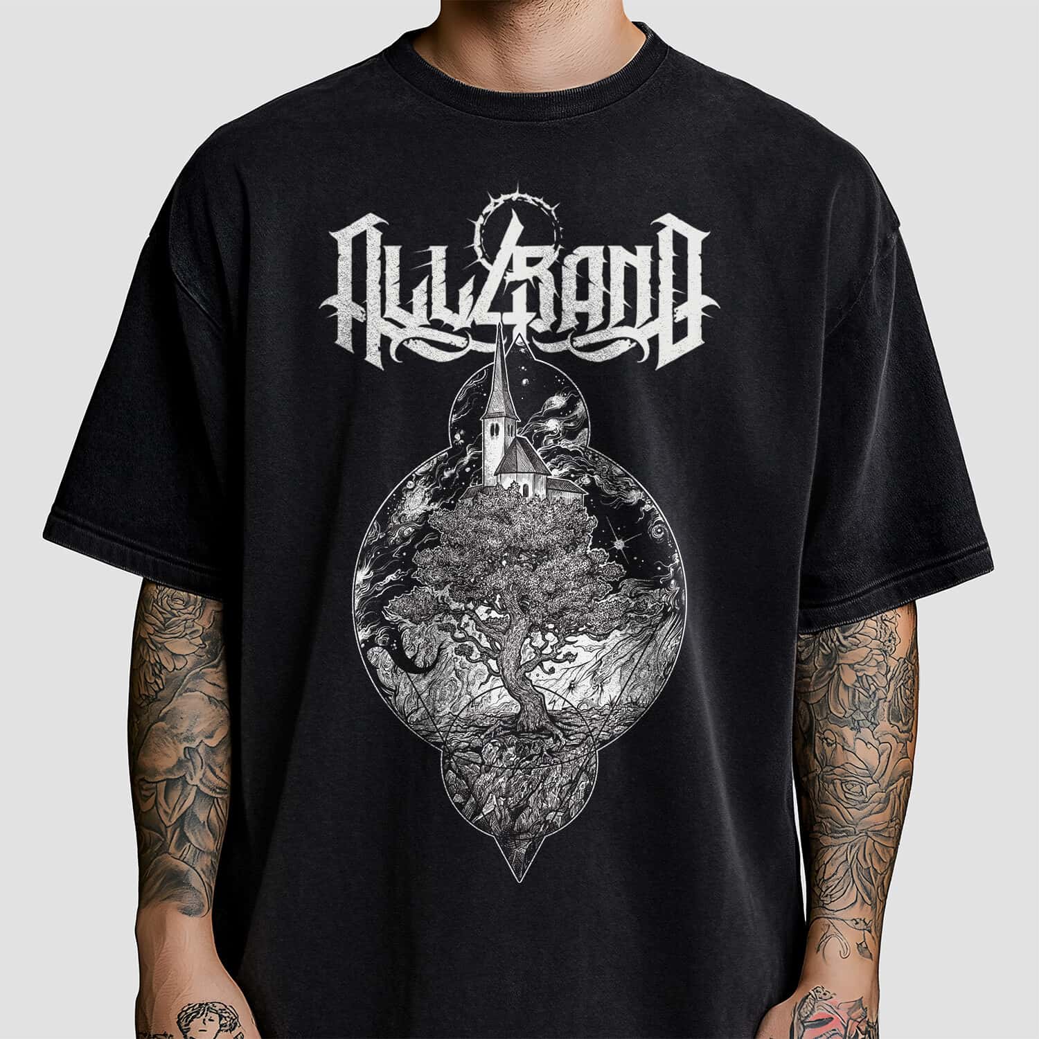 Black and white shirt design featuring a large ancient tree beneath a church surrounded by stars and swirling cosmic clouds.