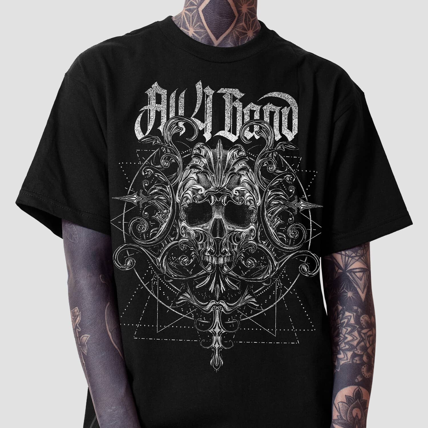 Black and white metal band shirt design featuring an ornate skull, baroque flourishes, and geometric patterns